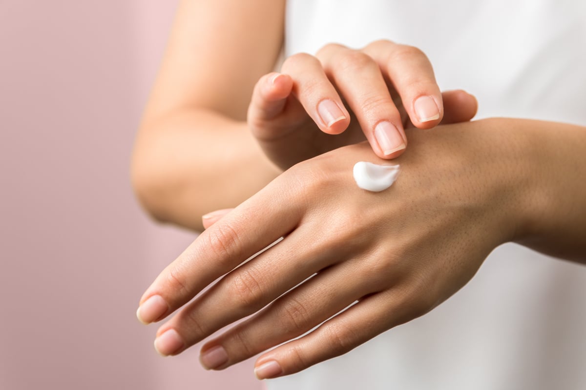 Hands spread white cosmetic cream